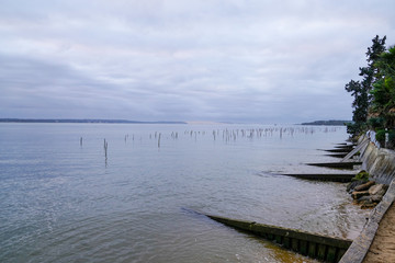 Oyster farm in Cap Ferret with Arcachon Dune du Pilat view in sunrise winter day