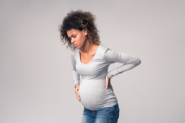 Pregnant woman suffering from abdominal and back pain - obrazy, fototapety, plakaty