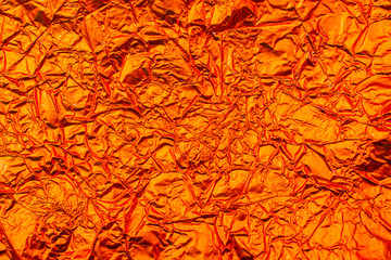 Texture of orange crumpled foil.