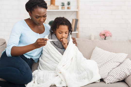 Afro Mum Measuring Temperature Of Coughing Kid