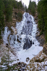 Fototapeta na wymiar Mountain waterfall partly frozen