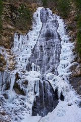 Mountain waterfall partly frozen
