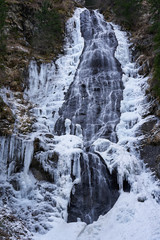 Fototapeta na wymiar Mountain waterfall partly frozen