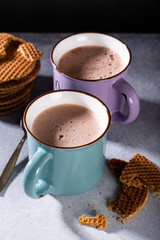 Two old mugs with hot chocolate milk on gray background. Background with copy space.
