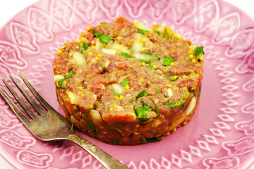 Beef Tartare cold appetizer of raw minced meat with egg yolk, spices, onions, olive oil, lemon juice