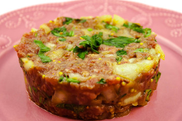 Beef Tartare cold appetizer of raw minced meat with egg yolk, spices, onions, olive oil, lemon juice