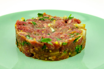 Beef Tartare cold appetizer of raw minced meat with egg yolk, spices, onions, olive oil, lemon juice