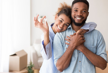 Afro Spouses Showing Key To Camera Embracing In New Home - Powered by Adobe