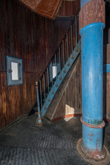 Old lighthouse on the inside. Red iron spiral stairs, round window and blue wall. Hiiumaa, small...