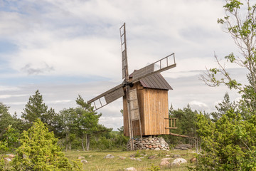 Fototapeta na wymiar Grain mill on the summer landscape. Windmill and natural background pattern. Hiiumaa, small island in Estonia. Europe