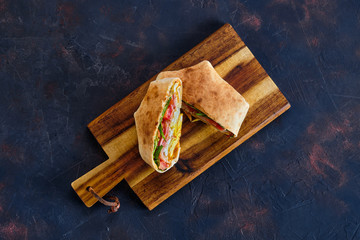 Top view of pita bread stuffed with ham, tomato and omelette