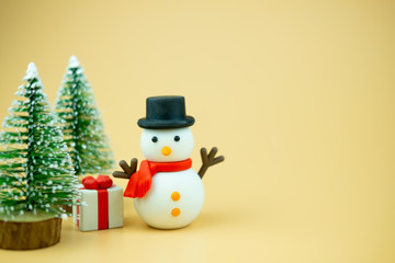 Christmas snowman toy, gift box and Christmas tree.