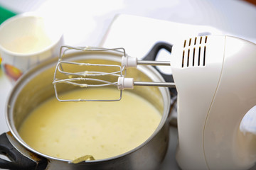An electric mixer stirs and whips the dough to bake a pie.