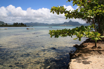 Fototapeta na wymiar Shallow, turquois, crystal clear water at a lagoon near Mahebourg, Mauritius with volcanic landscape in the background