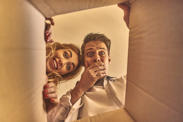 Happy couple opening the box after moving into new house.