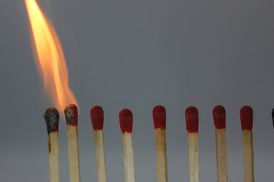 row if matches being lit by flame  in a chain reaction