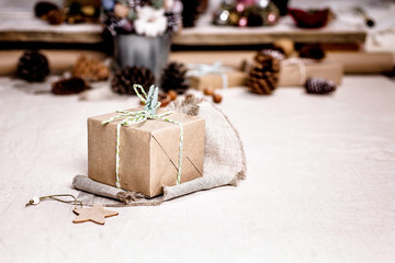 Fototapeta na wymiar Christmas gifts in the style of hugge or lagom. Kraft paper packaging and Christmas decor made from natural materials. Scandinavian interior style