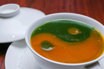 Vegetarian food, vegetable soup in a white cup on a wooden table