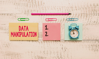 Conceptual hand writing showing Data Manipulation. Concept meaning the process of changing data to make it easier to read Blank notepads marker small alarm clock wooden vintage background