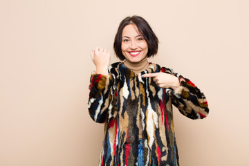 young pretty woman looking impatient and angry, pointing at watch, asking for punctuality, wants to...