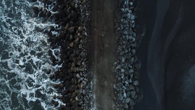 Heavy construction vehicles moving rocks on the coast in Vik, Iceland