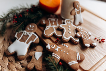 painted gingerbread man Christmas gingerbread cookies lie on a wooden board.