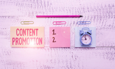 Conceptual hand writing showing Content Promotion. Concept meaning about getting content in front of the right audience Blank notepads marker small alarm clock wooden vintage background
