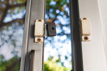 Broken security magnetic lock contact for mosquito wire screen window, Repair Room concept
