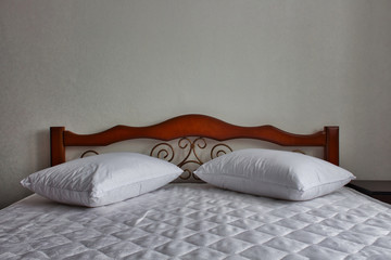 white sheets and pillows on the mahogany bed