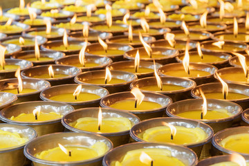 Rows of burning candles at a church. Temple interior