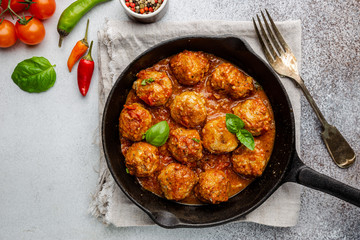 Meatballs with spicy tomato sauce on a frying pan, view from above, top view