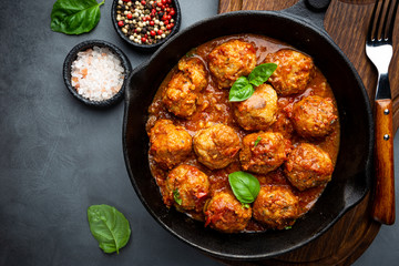 Meatballs with spicy tomato sauce on a frying pan, view from above, top view
