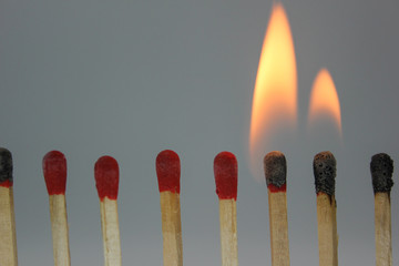 row if matches being lit by flame  in a chain reaction