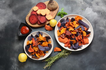 Baked vegetable chips- garnet sweet potato, purple sweet potato,carrot and beetroot. Gluten-free, dairy-free and vegan. Healthy food concept
