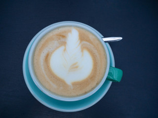 Latte art in blue coffee cup or mug on trendy wooden background