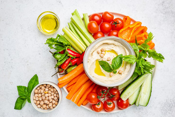 Hummus platter with assorted snacks. Hummus in bowl and vegetables sticks. Plate with Middle...