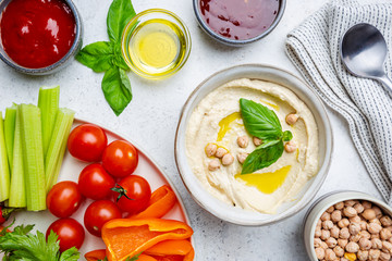 Bowl of healthy homemade creamy chickpea hummus dip with olive oil, top view