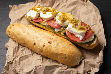 Goat cheese and honey sub sandwich on dark background