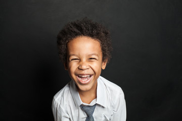 Little boy african american child laughing on chalkboard background