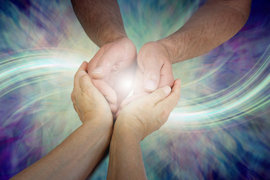 Sharing my Energy with You - female hands cupped lovingly around male cupped hands against a flowing energy formation background with copy space