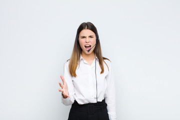 young pretty woman looking angry, annoyed and frustrated screaming wtf or what‚Äôs wrong with...