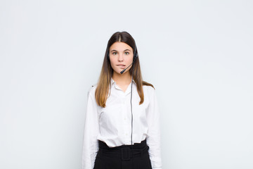 young pretty woman looking puzzled and confused, biting lip with a nervous gesture, not knowing the...