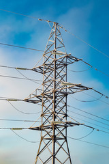 High-voltage electric line tower against a blue sky.