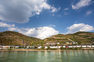 Beautiful German landscape with tiered vineyard and village seen from the middle Rhine River.