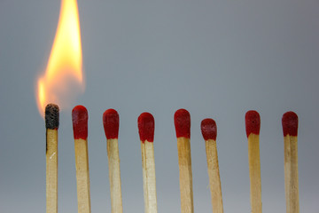 row if matches being lit by flame  in a chain reaction