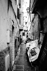 Black and white picture of a messy side street used as temporary storage at the old souk in Casablanca, Morocco
