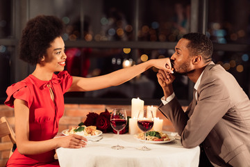 Man Kissing Woman's Hand Dining In Restaurant Celebrating Valentine's Day