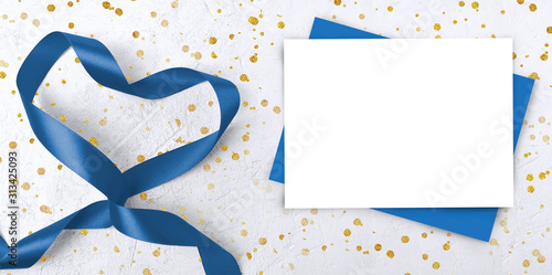 Mock up Valentines day composition in trendy blue color. Empty paper blanks, ribbon heart on white background with golden confetti. Mothers day or wedding greeting concept.