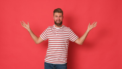 Happy young man in white shirt with red stripes looking excited.