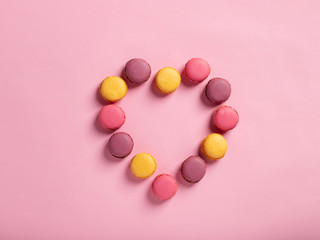Fototapeta na wymiar valentines day card. women's Day. Heart shape made of delicious macarons on a pink background.